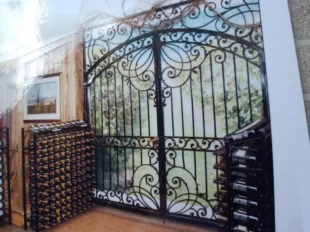 Elegant wrought iron gates with wine racks beside.