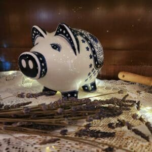 Decorative ceramic piggy bank on lace with lavender.