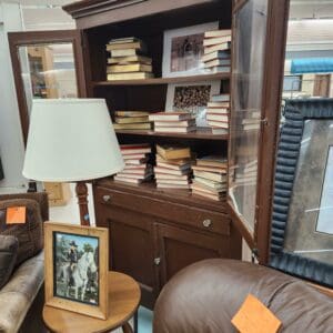 Antique bookshelf, books, lamp, and framed picture in store.