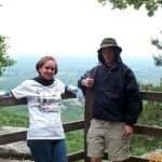 Two hikers at scenic overlook giving thumbs-up.