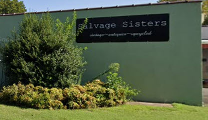 Salvage Sisters store sign with greenery.